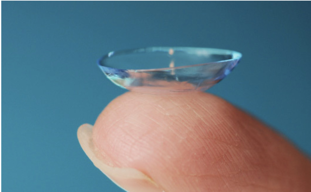 Bandage contact lens balanced on a fingertip